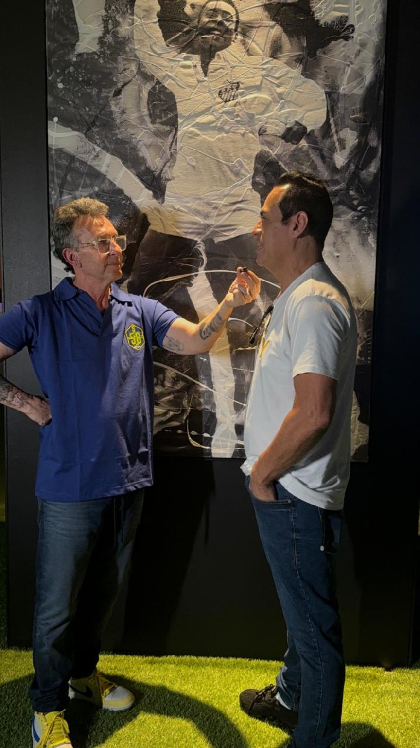 Registro de conversa diante de pintura monumental dedicada a Pelé.